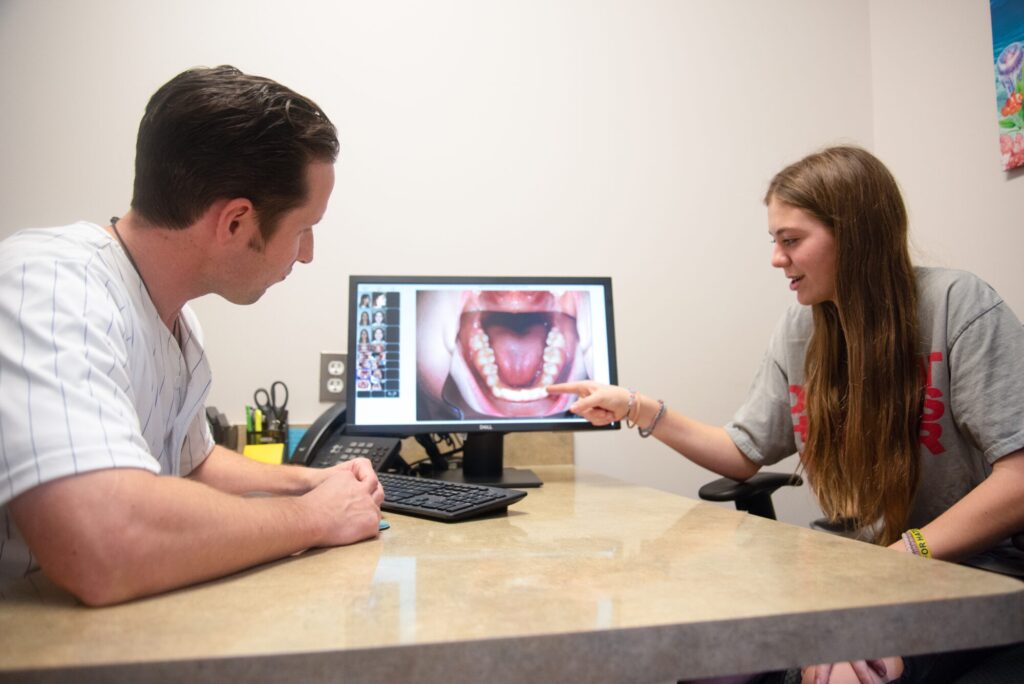 Orthodontist reviewing an intraoral photo of the palate and throat with a young patient on a monitor during a Grosse Pointe orthodontics consultation for Clinton Township braces at Lifetime Orthodontics